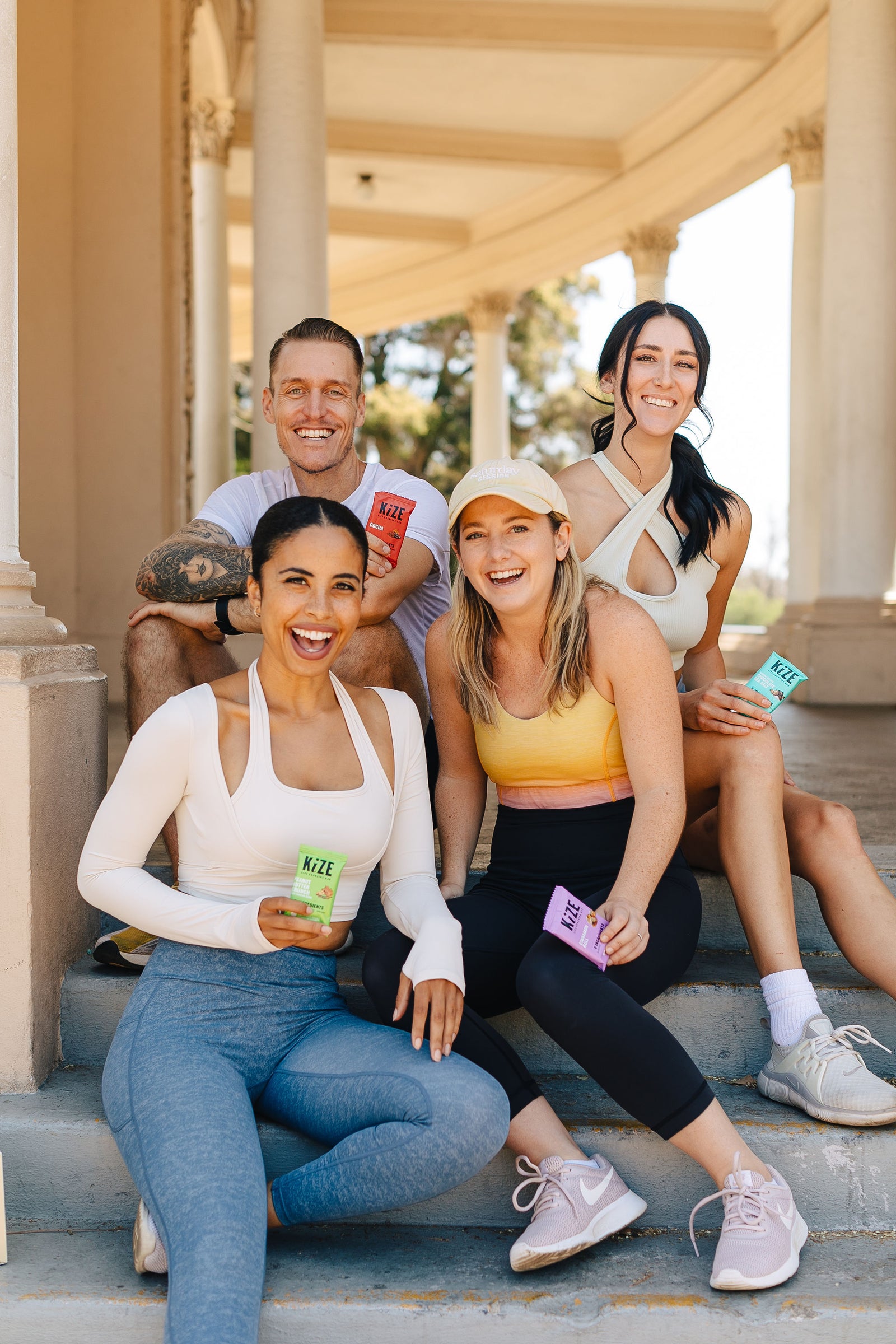 Group of People Smiling Holding Kize Bars