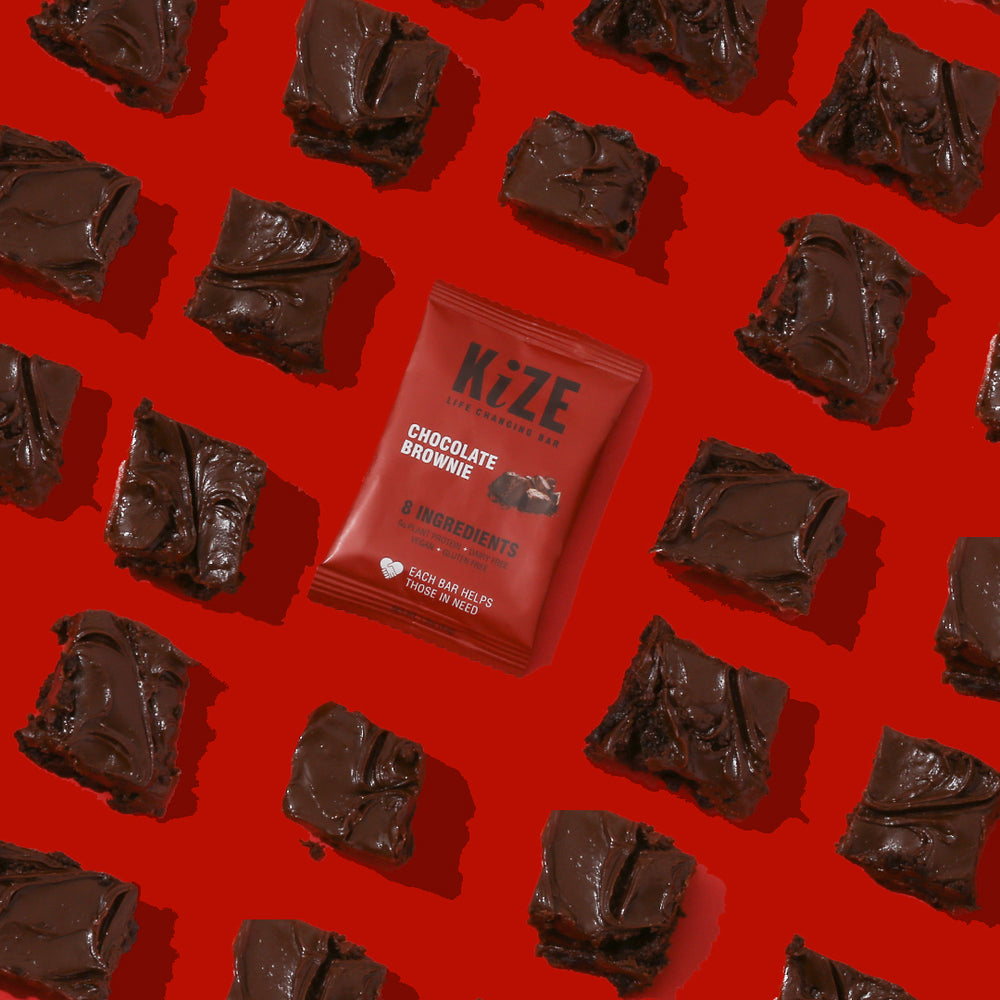 Kize Chocolate Brownie Protein Bar in Package surrounded by Brownies